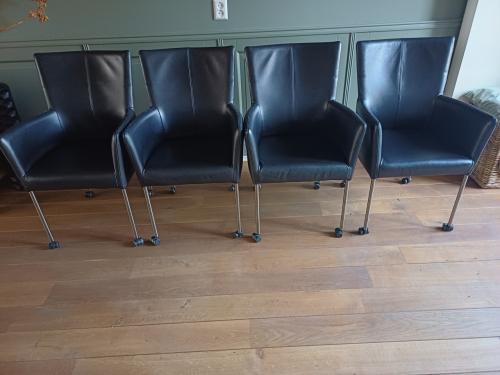 Vier zwart lederen eetkamerstoelen