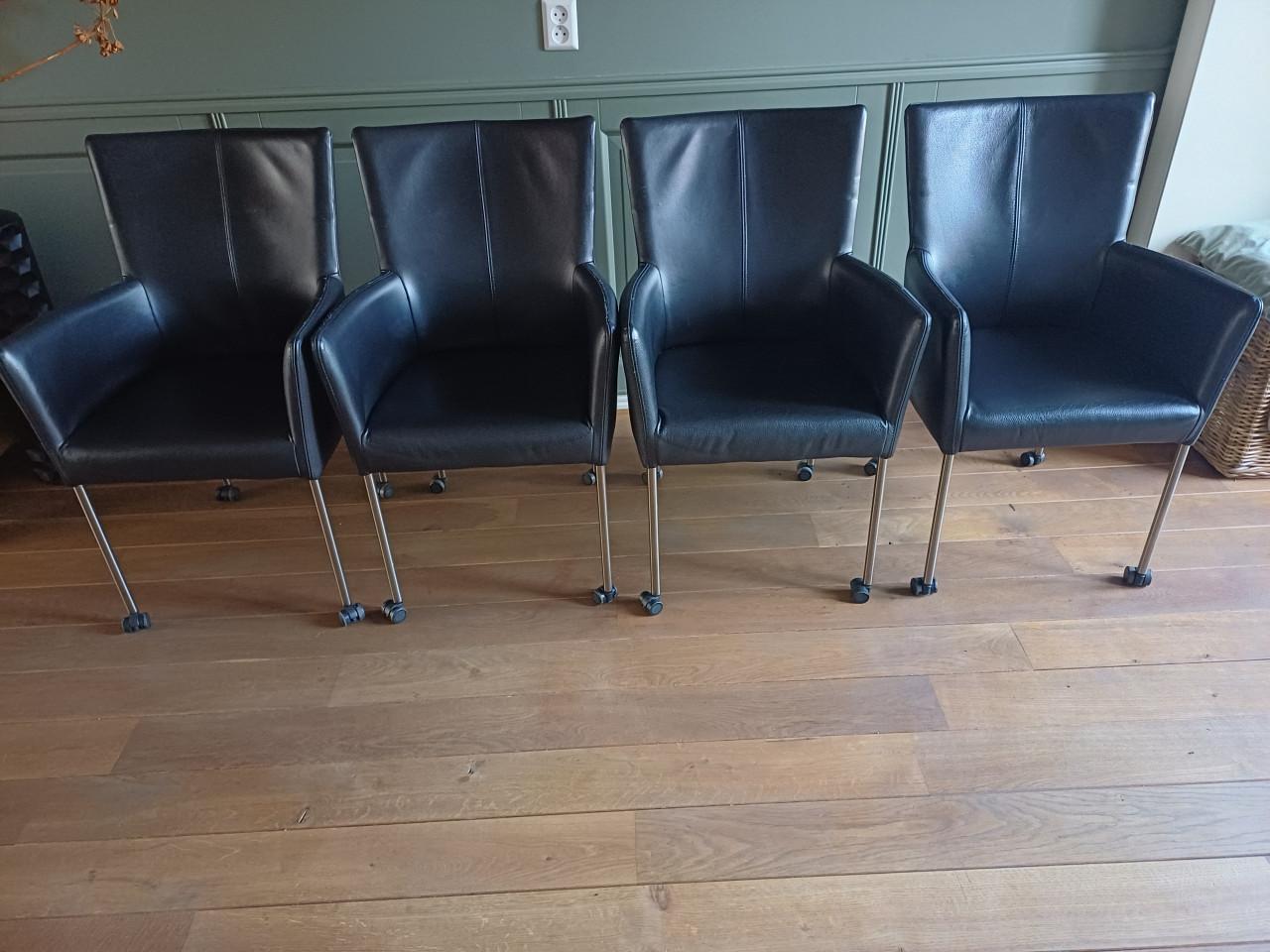 Vier zwart lederen eetkamerstoelen