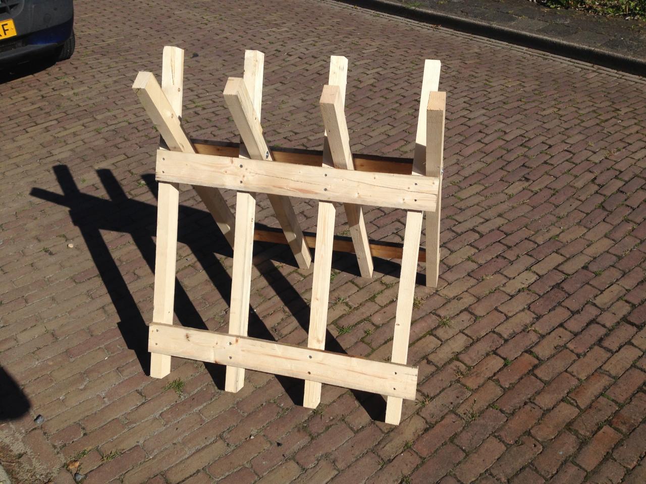 Veel haardhout doorzagen met kettingzaag en robuste stabiele zaagbok