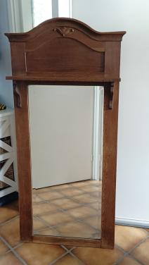 Antieke houten spiegel met sierlijke lijst.