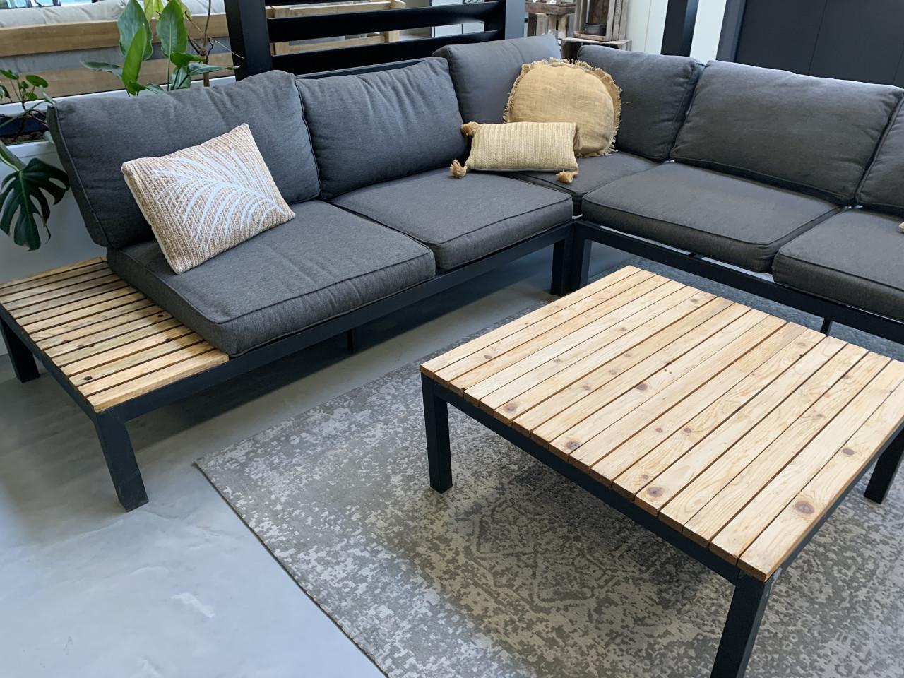 Zwart aluminium loungeset met houten plateaus, en tafel en kussens.