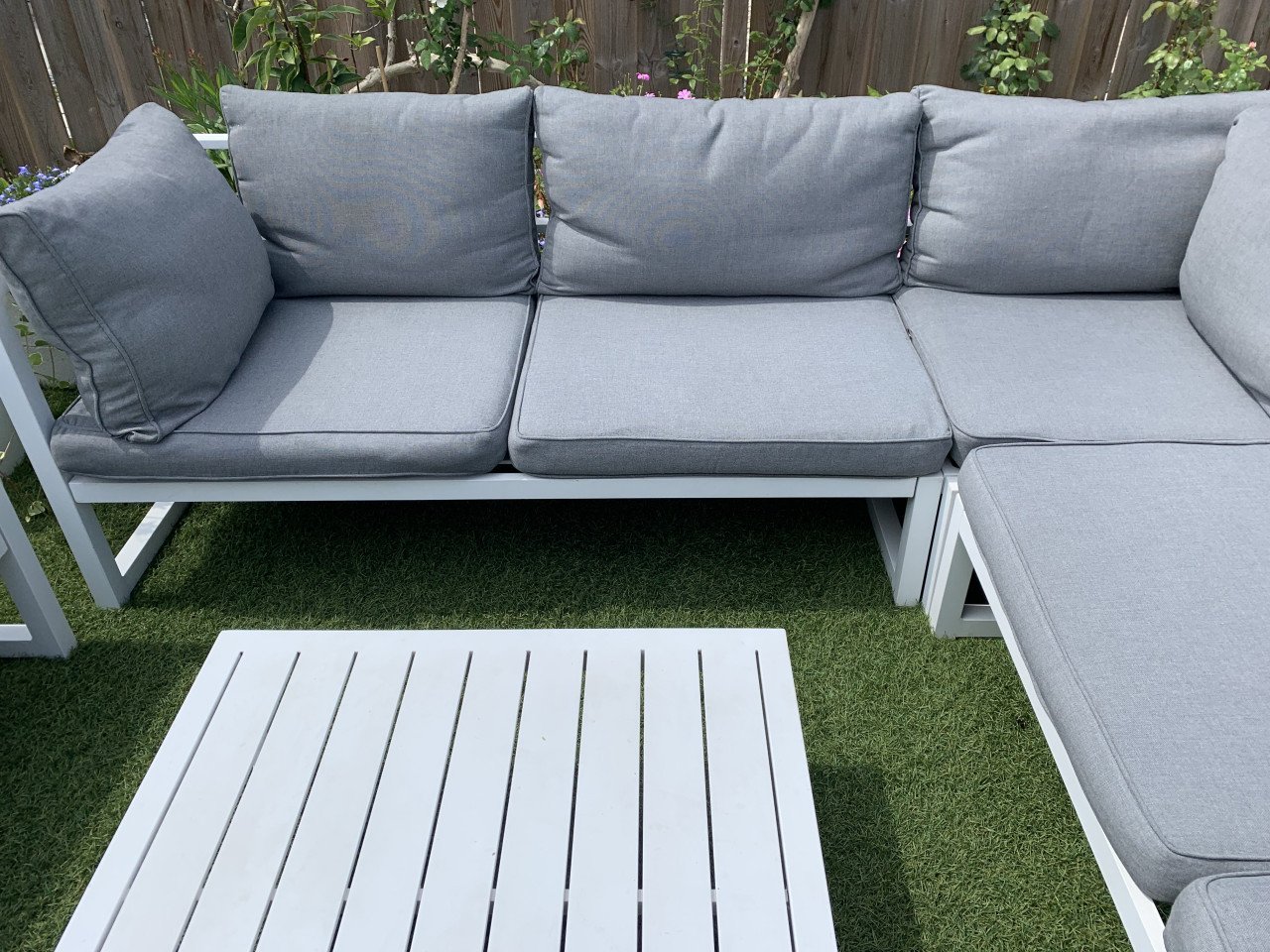 Wit aluminium loungeset met kussens tafel en stoel.
