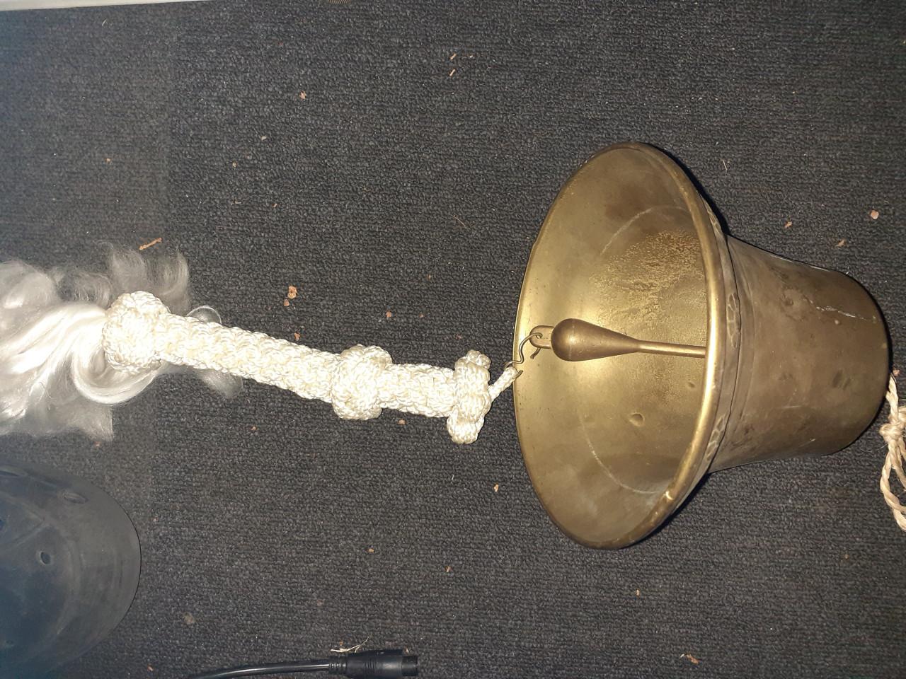 Scheeps bel koper met kort eindje gevlochten touw