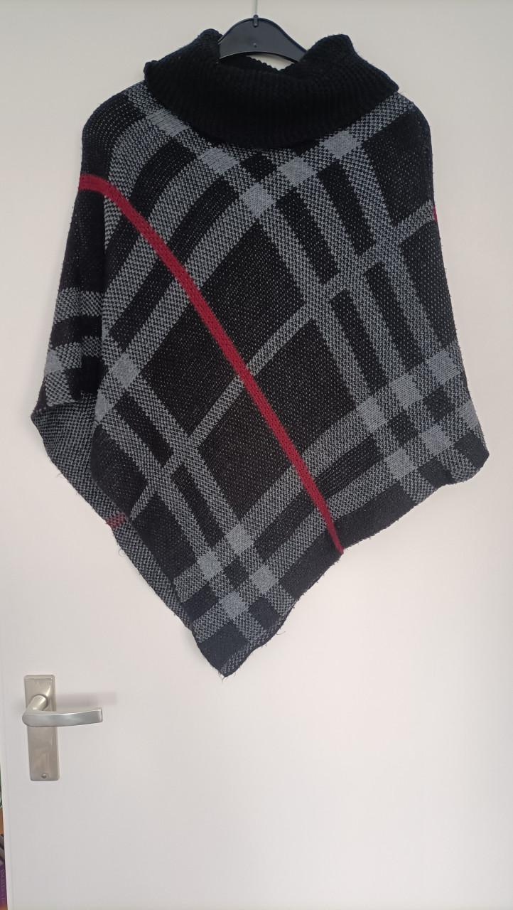 Leuke poncho. Basiskleur zwart met een grijs streepje en één donkerrode.