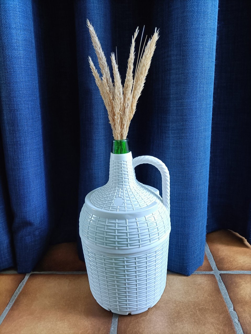 Brocante 5 liter groene glazen wijn / kruikfles in witte kunststof mand.
