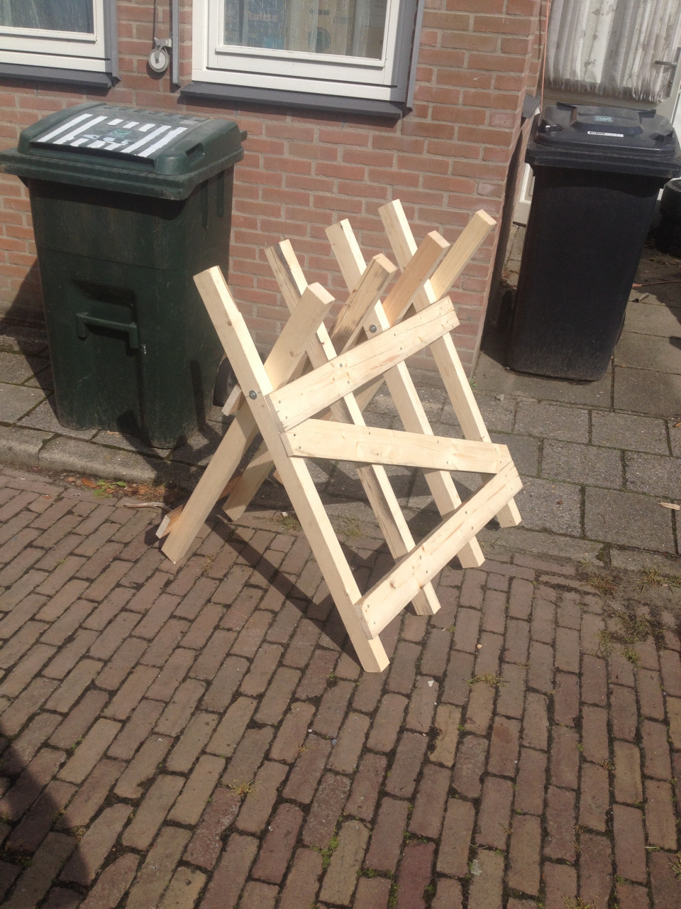 Rechtop hout doorzagen met kettingzaag en robuste zaagbok als werkbank