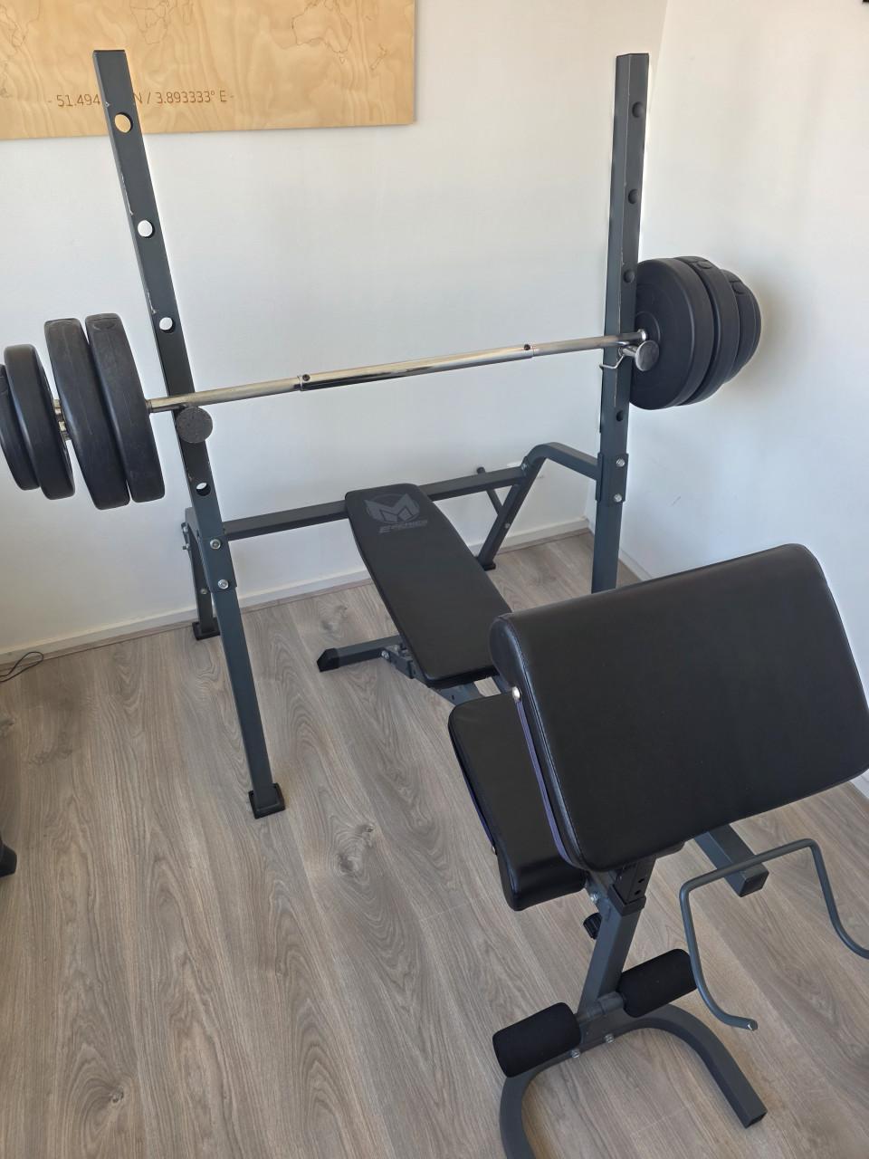 Fitnessbank met halterstang en gewichten
