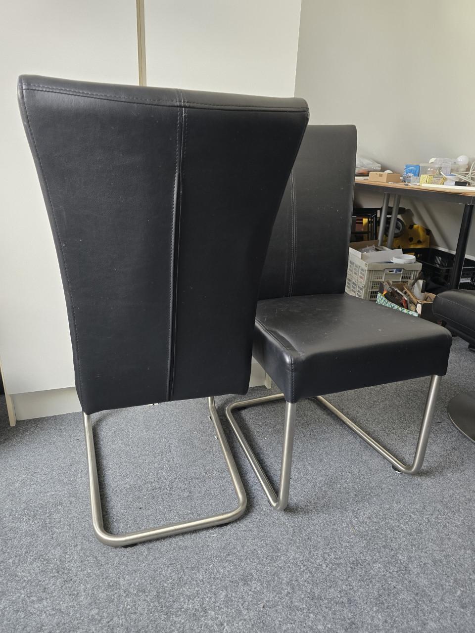 Zwarte leren eetkamerstoelen en fauteuil met poef
