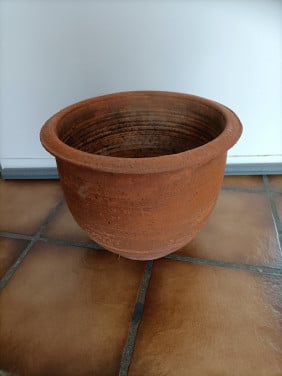 Terracotta buiten planten pot. In de bodem zit een gat voor de waterafvoer.