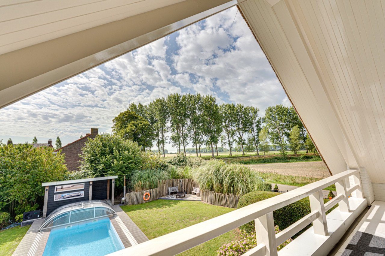 Rietgedekte villa met een overdekt zwembad.