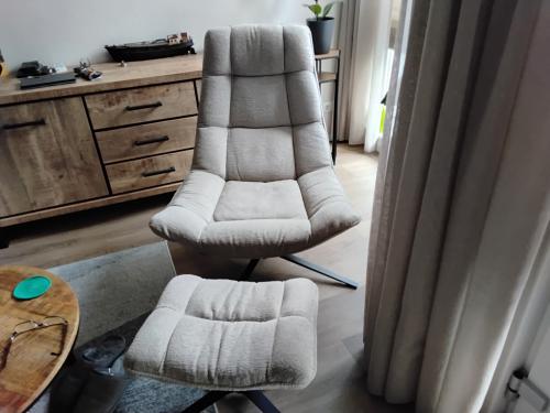 Stoffen beige relexstoel met hocker