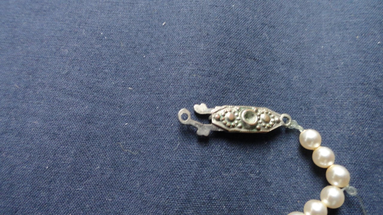 Ketting met van klein naar groot (nep) parels. Met fraai slotje.