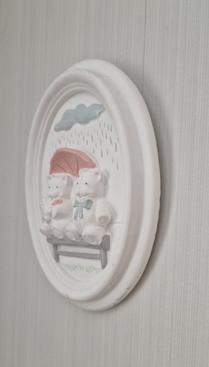 Schattige wanddecoratie van gips met 2 beertjes op een bankje in de regen