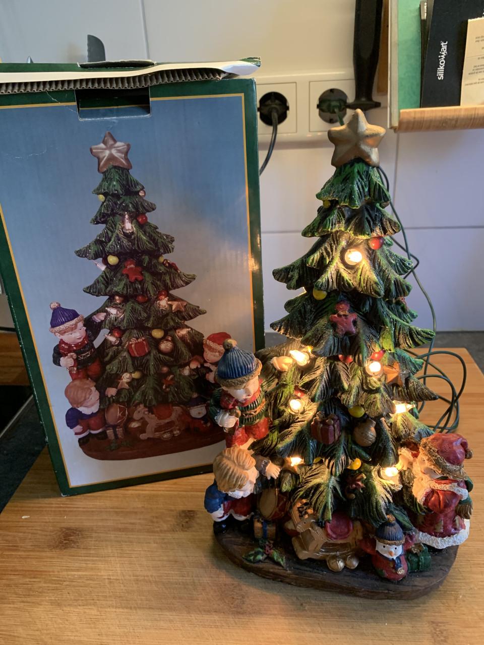 Verlichte keramieken kerstboom met kinderen