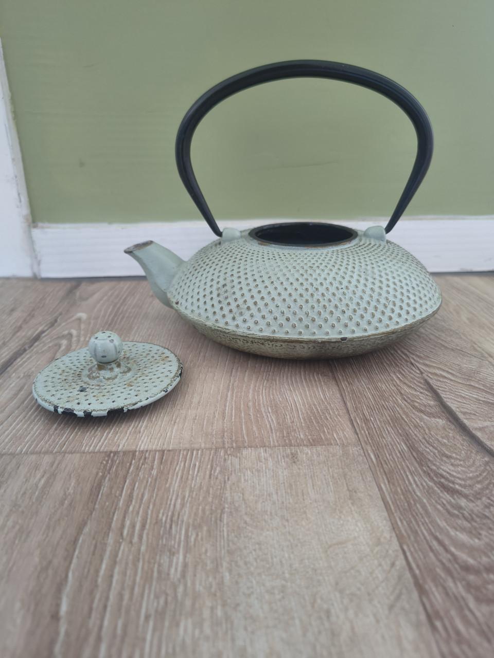 Prachtige groene gietijzeren theepot met hengsel en deksel.