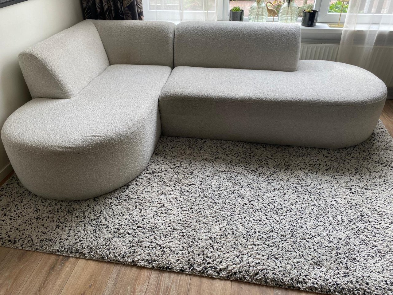 Mooie trendy crèmekleurige hoekbank, teddystof