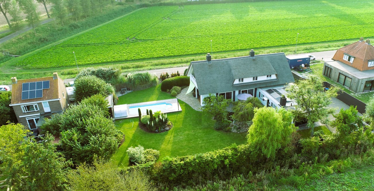 Rietgedekte villa met een overdekt zwembad.