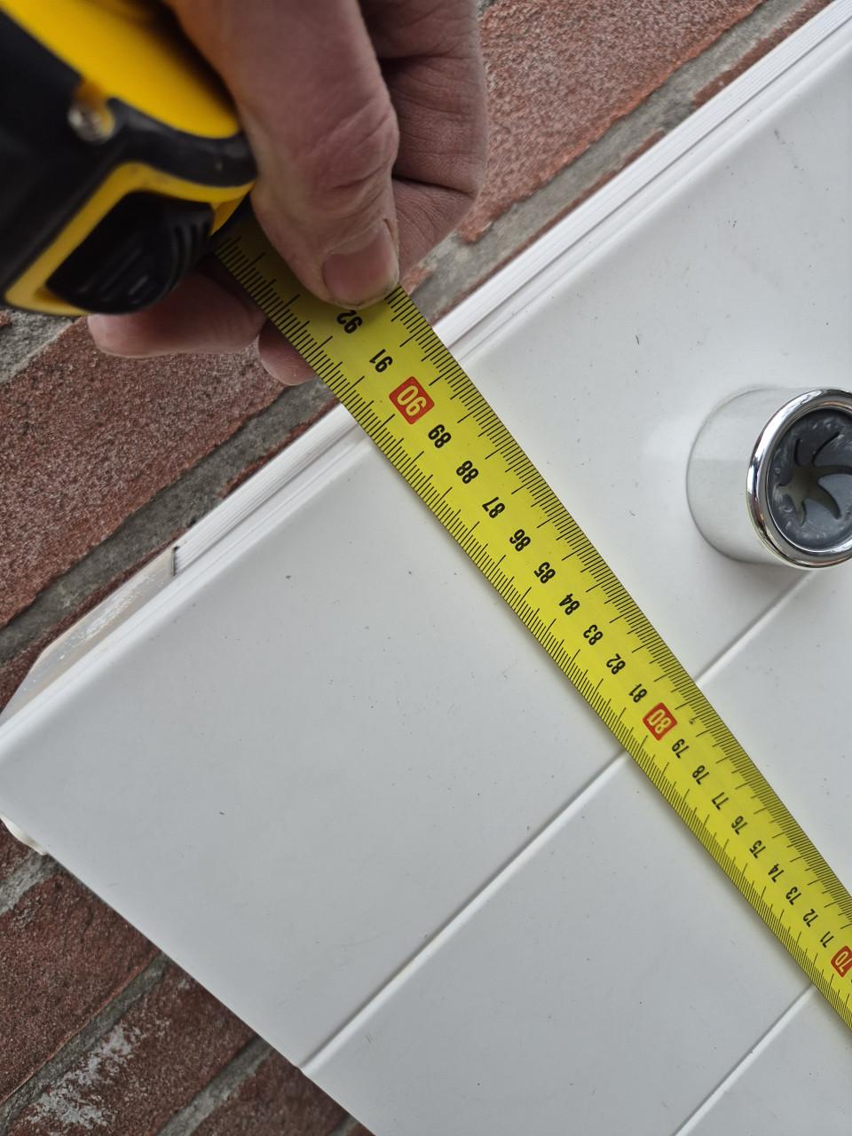 Nette radiator met ophangsysteem en thermostaatknop.