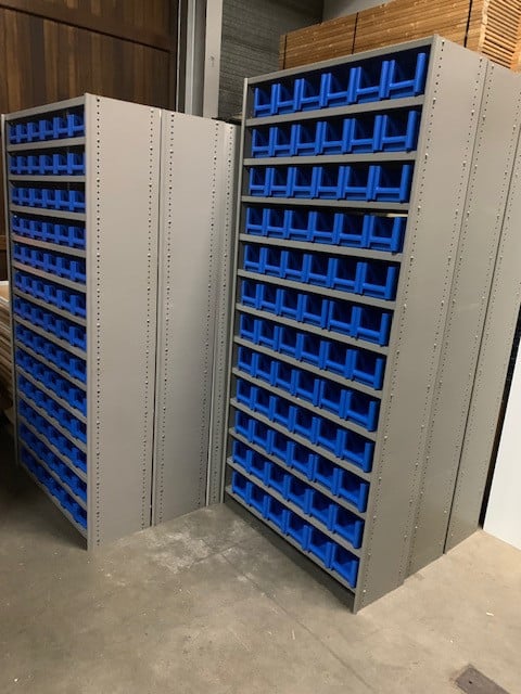 Diverse stellingen gevuld met kunststof magazijnbakjes