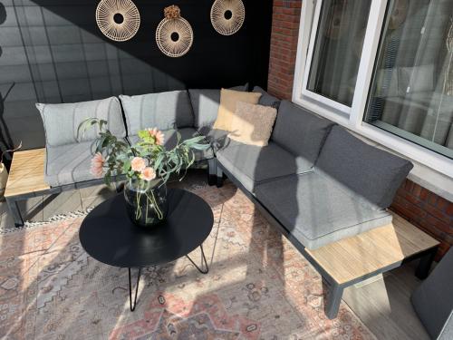 Zwarte loungset met houten plataus, kussens en tafel