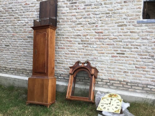 Antieke staande klok in onderdelen