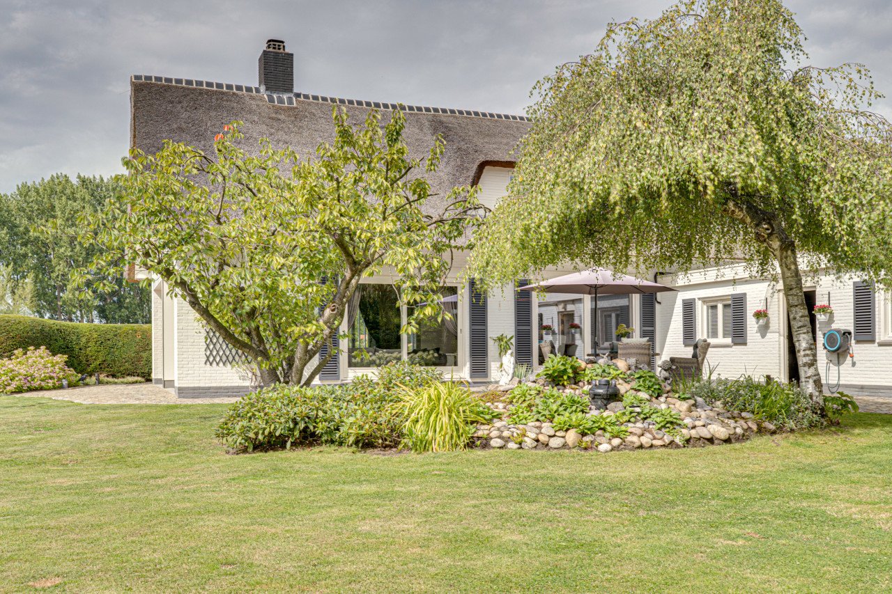 Rietgedekte villa met een overdekt zwembad.