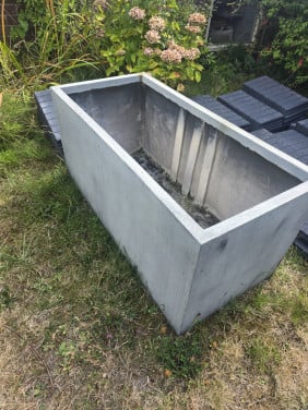 Grijze betonnen bloembak