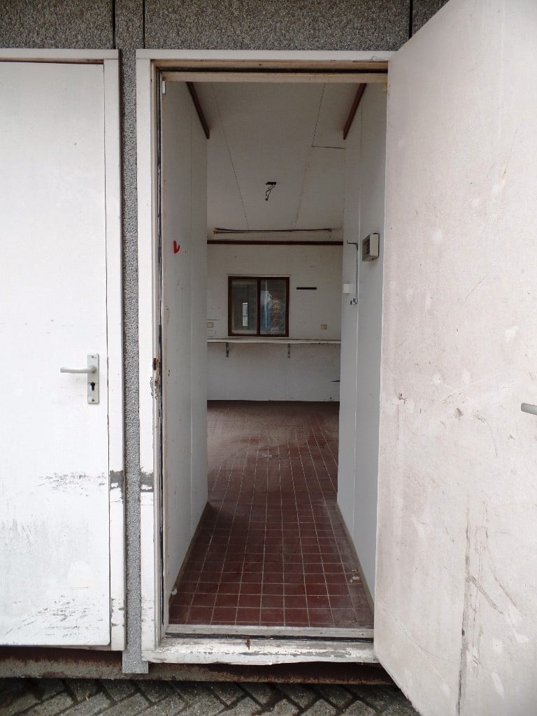 Verkoopunit met betonnen vloer, apart toilet met wastafeltje en rolluik