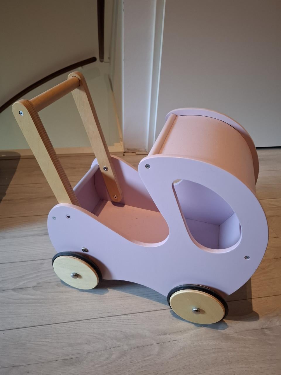 Roze houten kinderwagen