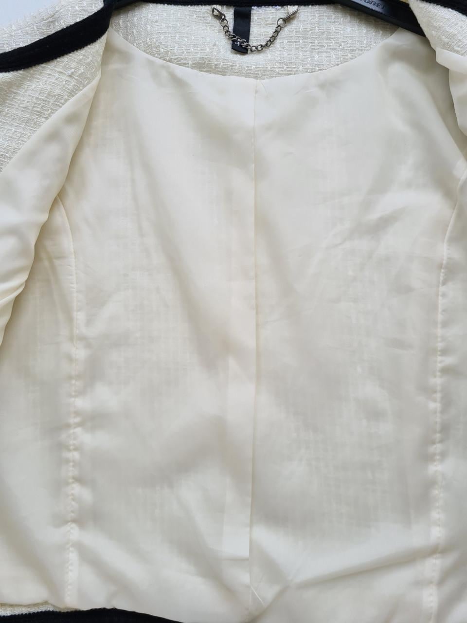 H&M bouclé jasje in de kleur room wit met zwarte bies. Maat 40