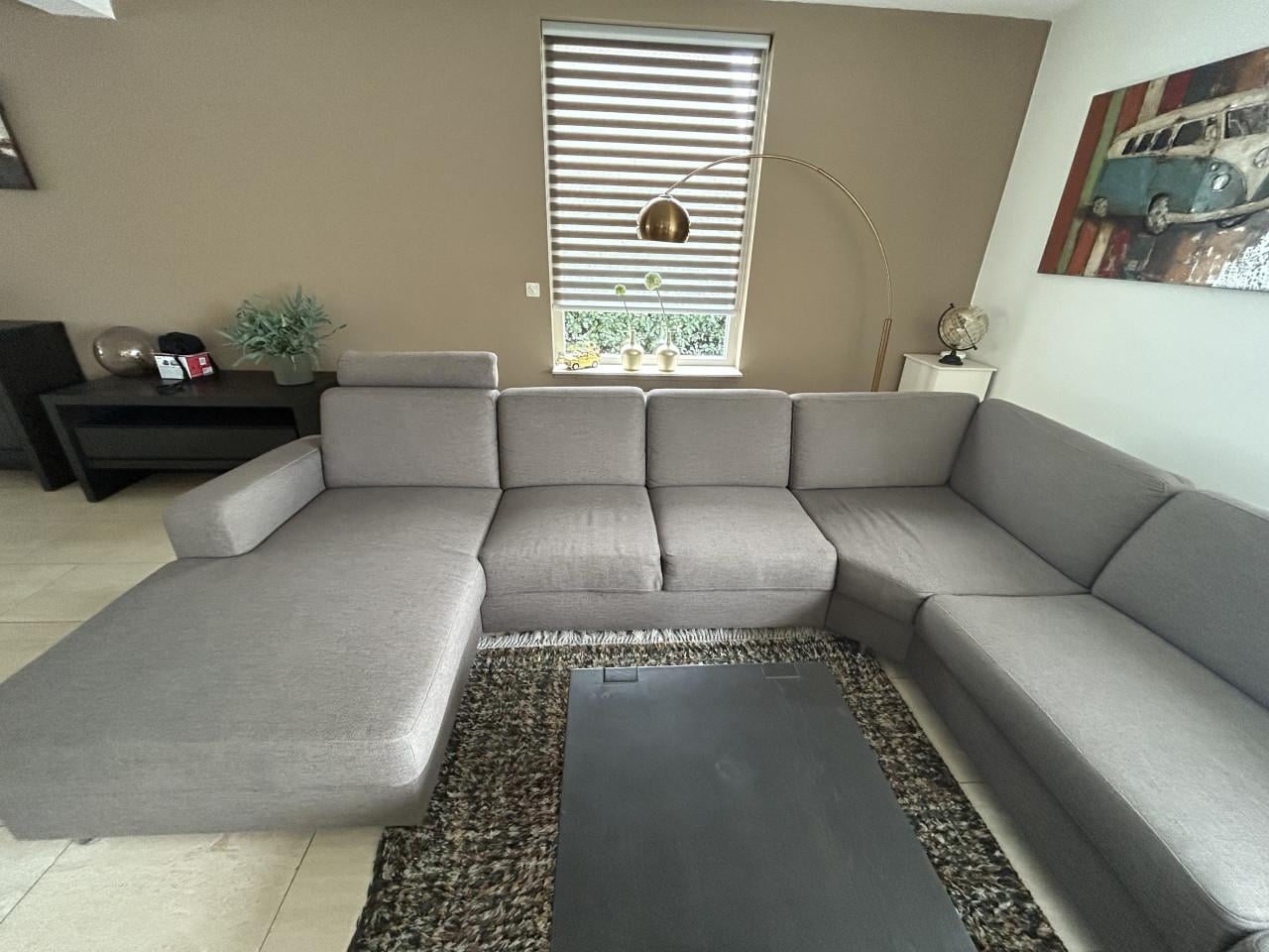 Mooie hoekbank met loungegedeelte en hoofdsteunen in Taupe kleur.