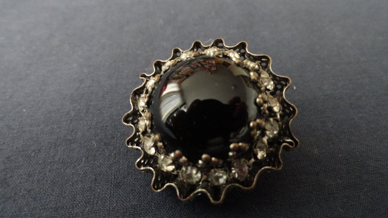 Speld met zwarte steen met strass steentjes eromheen. Leuk ding. (zie foto’