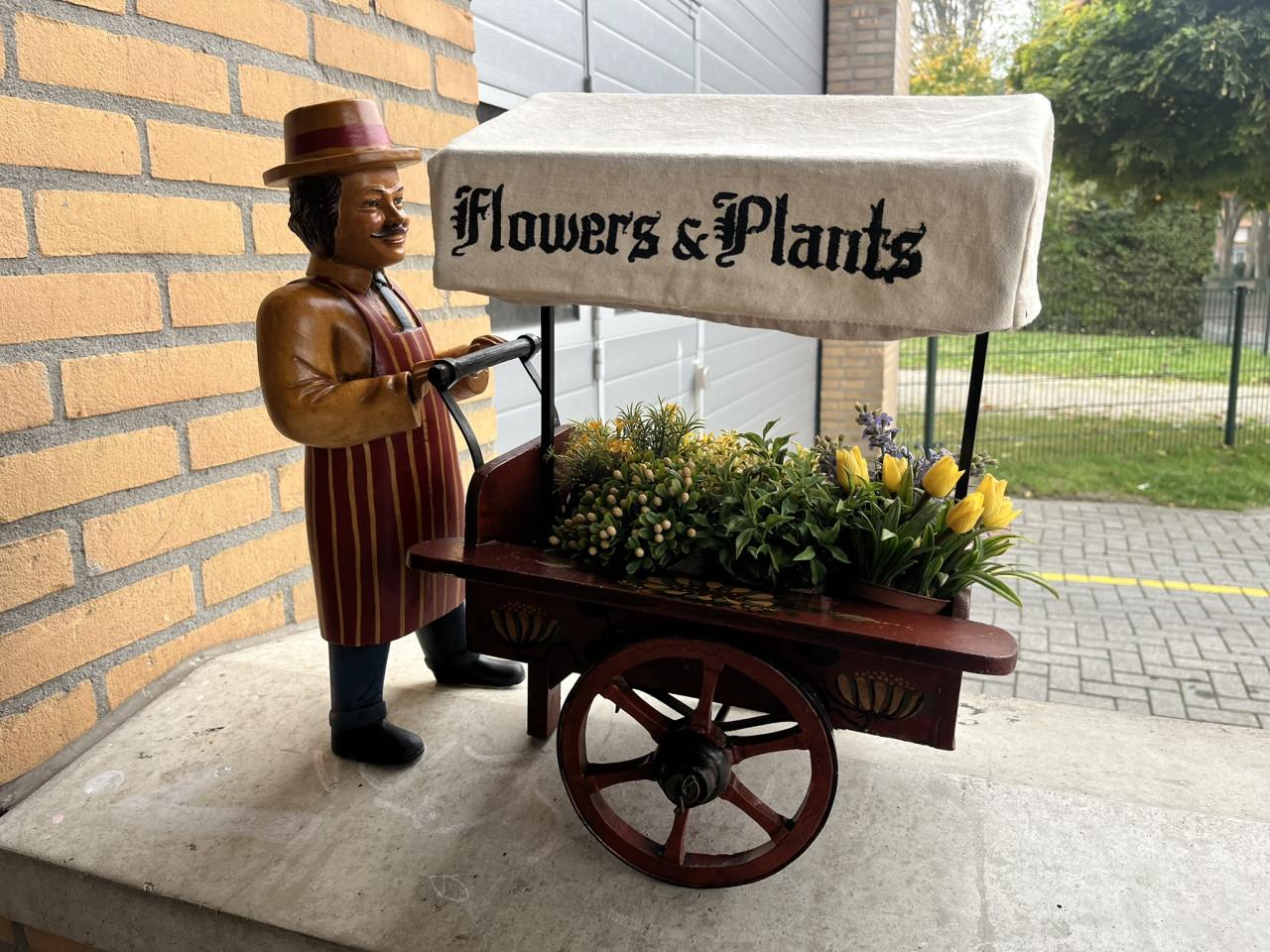 Miniatuur bloemkarretje met pop