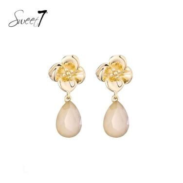 Oorbellen bloem design met zachte beige druppelvormige hanger