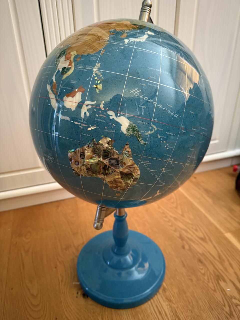 Wereldbol ingelegd met edelstenen op standaard van turkoois