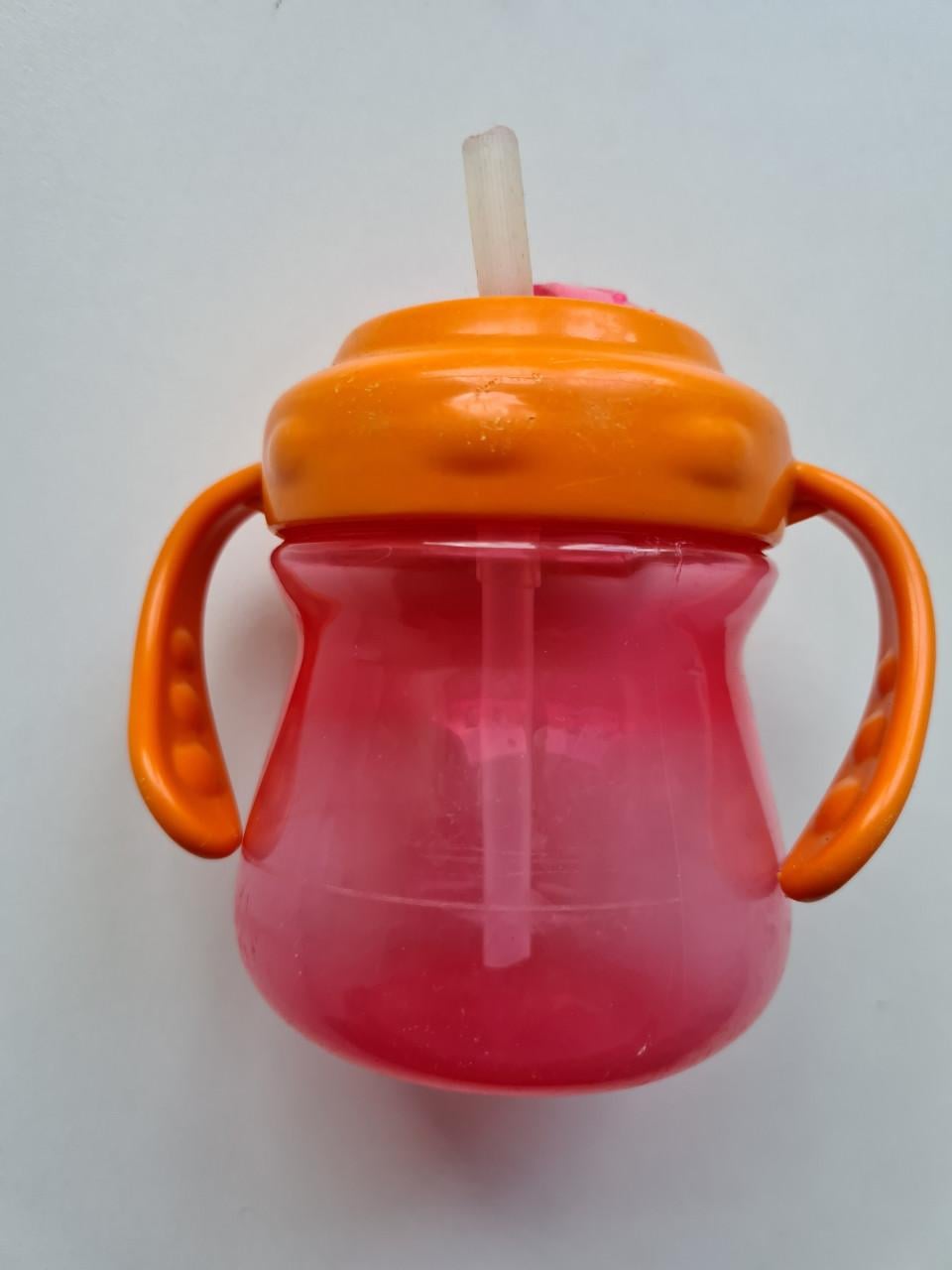 Munchkin Tip & Sip rietjesbeker met oranje deksel en roze beker.