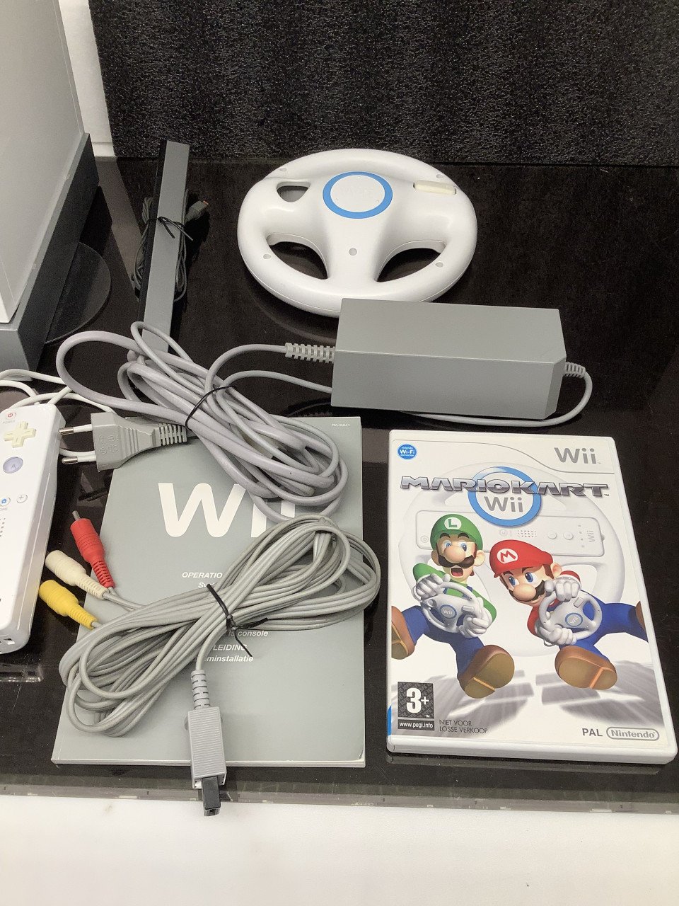 Nintendo Wii met controller en spellen, o.a. Mario Kart met stuur.