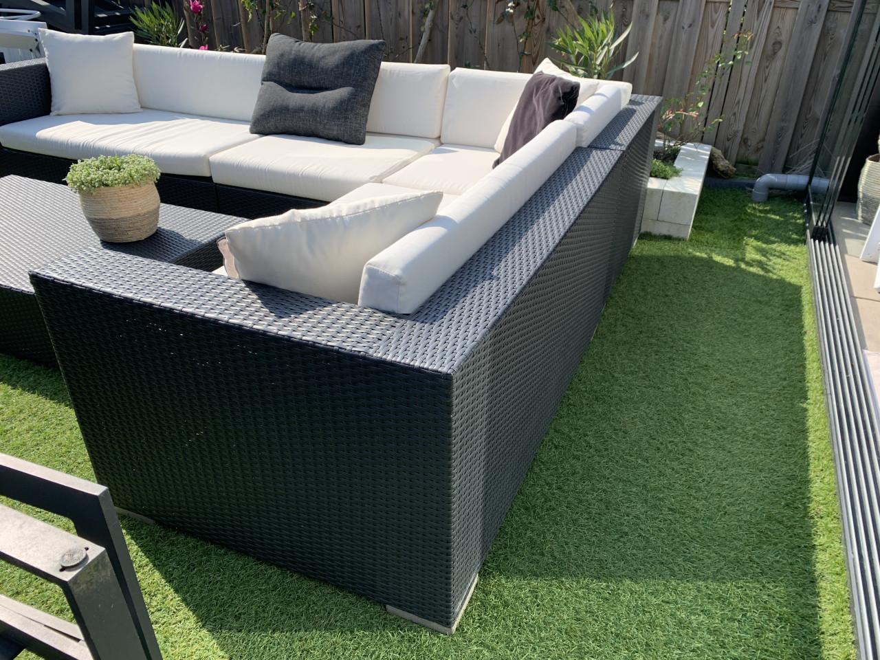 Wicker loungeset zwart met kussens en tafel.