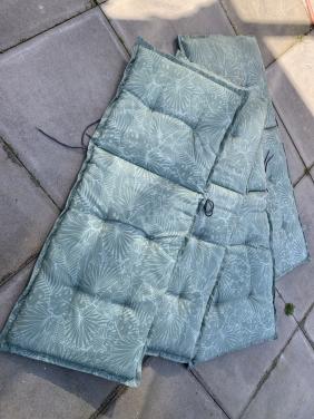 Vier  tuinstoelkussens met een groene bladprint. Met hoes