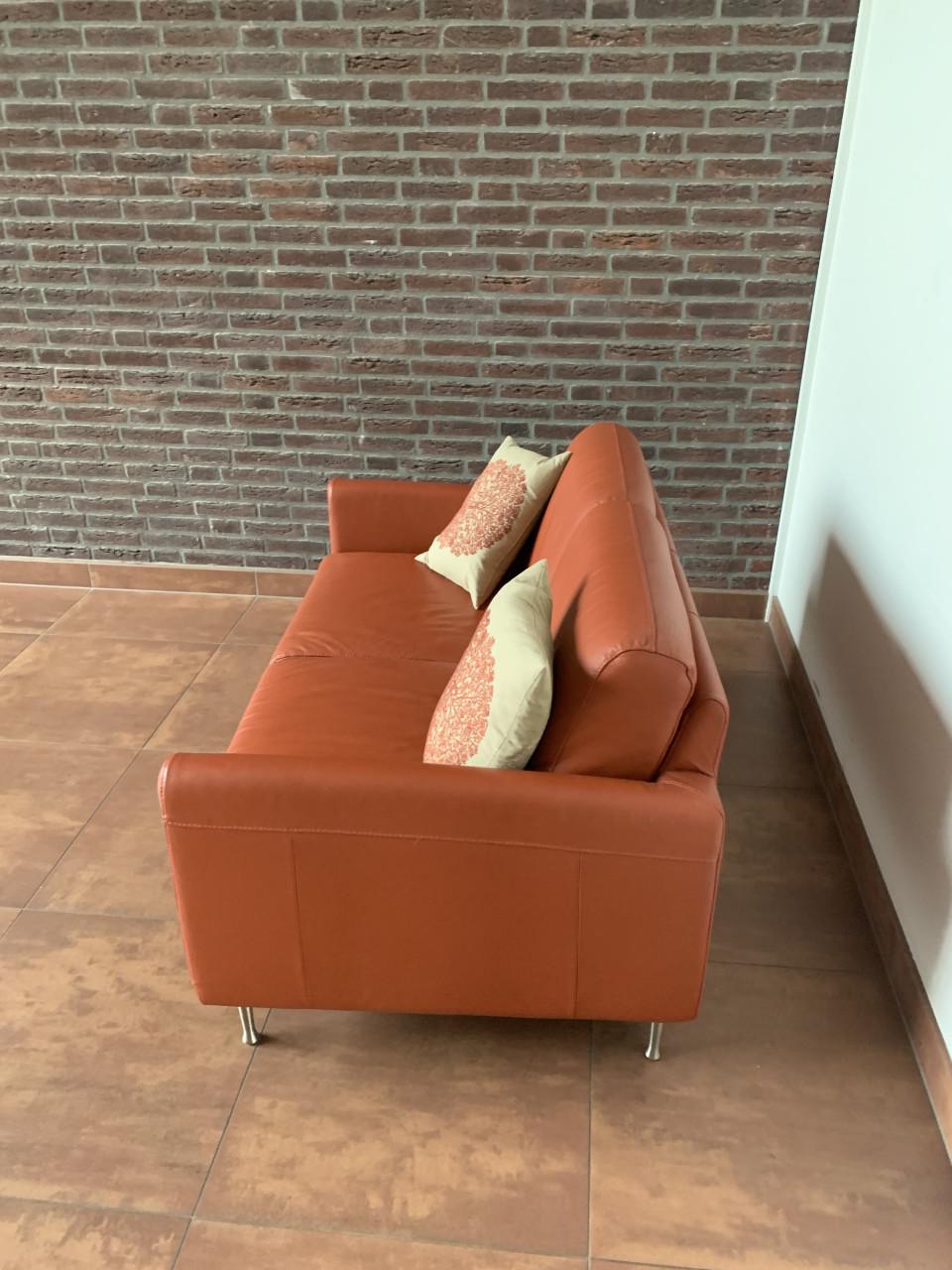 Leuk oranje kleurig bankje met twee kussens