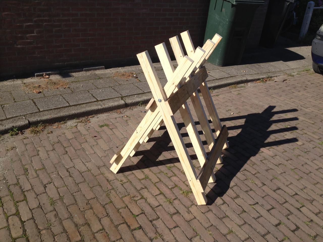 Rechtop hout doorzagen met kettingzaag en robuste zaagbok als werkbank