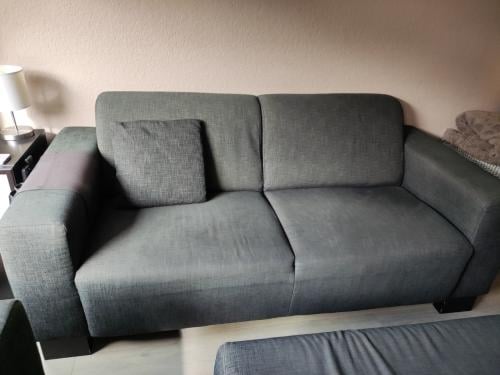 GRATIS! Comfortabele grijs/zwart 2,5 & 3 zits bank + poef