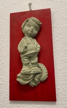 Houten bordje met stenen beeldje erop