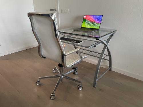 Te Koop: Glazen computer bureau met metalen frame.