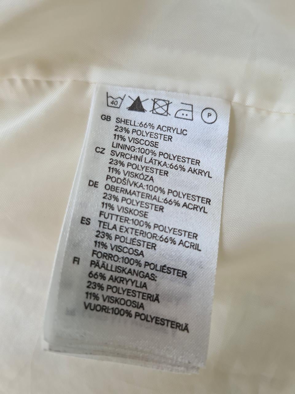 H&M bouclé jasje in de kleur room wit met zwarte bies. Maat 40