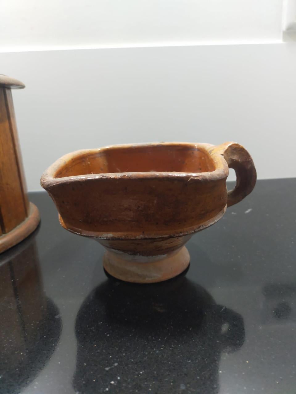 Antieke ronde voetenstoof met aardewerk schaaltje