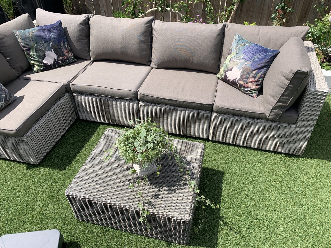 Rieten loungeset met kussens en tafel.