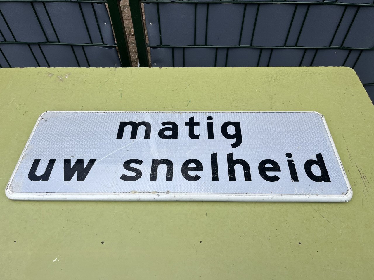 Verkeersbord "matig uw snelheid "