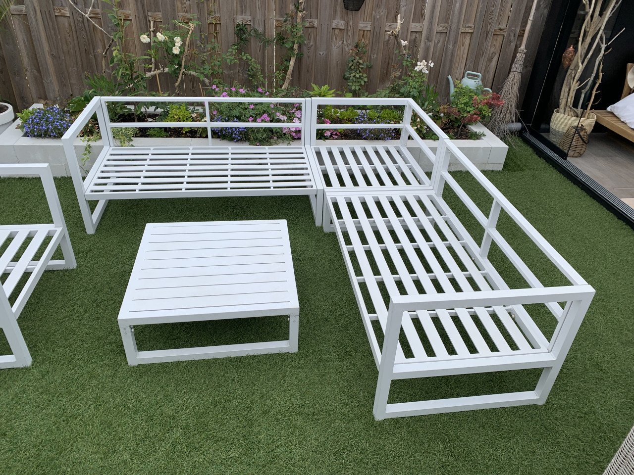 Wit aluminium loungeset met kussens tafel en stoel.