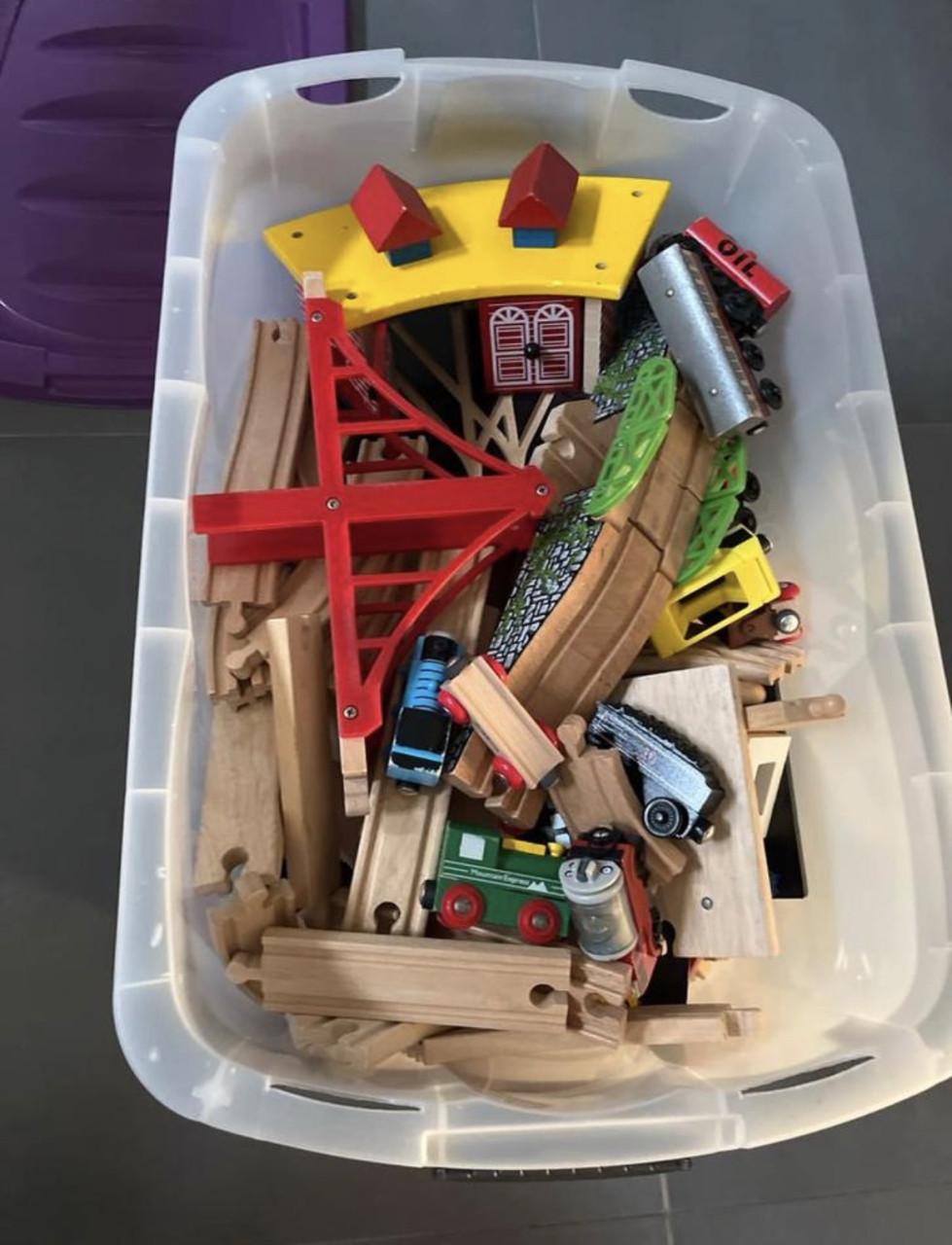 Grote bak met houten treinbaan en treintjes op batterij